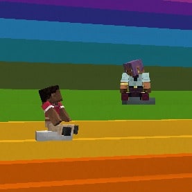 Efe and Zuri are looking each other while they are sitting on cushions on a concrete rainbow staircase.