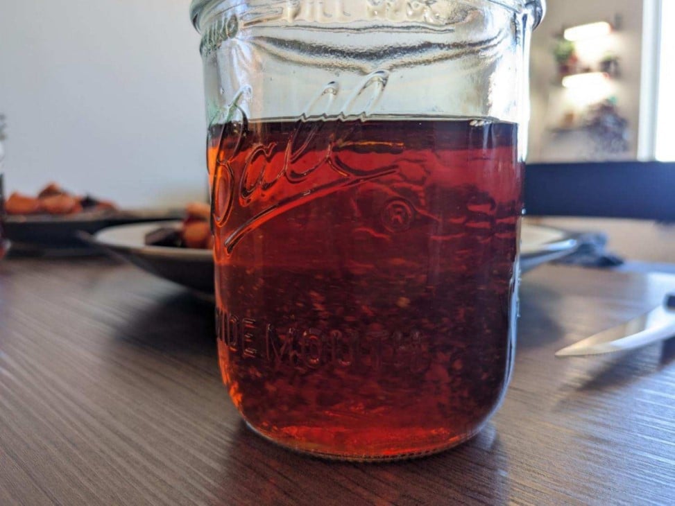 Photo of a dark, reddish beverage in a clear glass