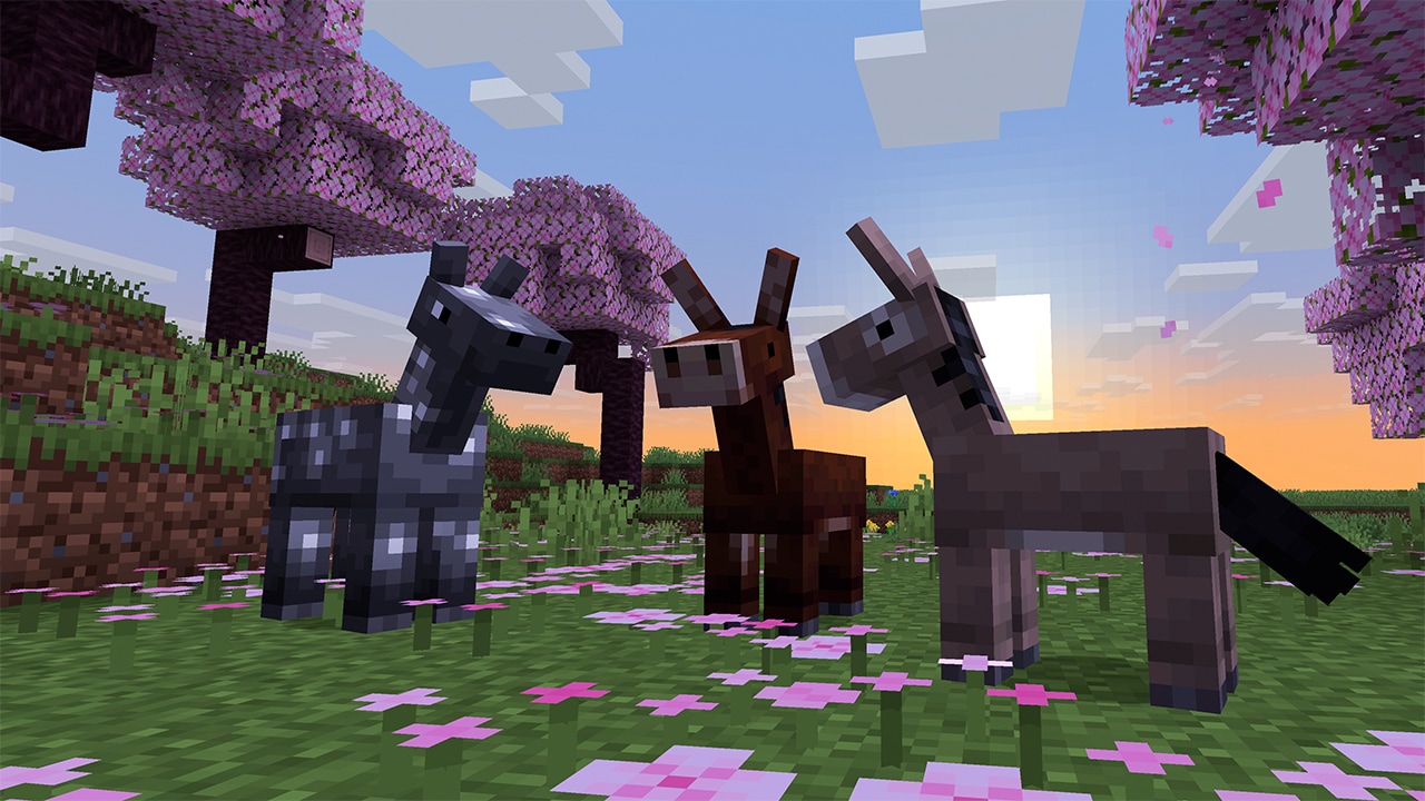 A gray foal with white spots, a baby mule, and a baby donkey stand together on a grassy hill covered with pink petals. Cherry blossom trees surround them, and the sun sets in the distance, casting warm light across the scene.