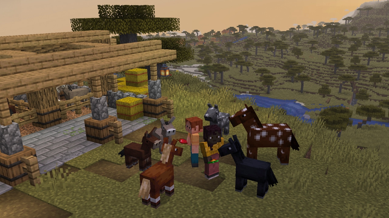 A player stands outside a wooden stable surrounded by foals with different coat patterns, a baby donkey, and a baby mule. Hay bales, fences, trees, a river, and rolling grassland appear in the background.