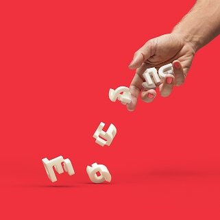 Blokkede bogstaver, der falder ud af en hånd