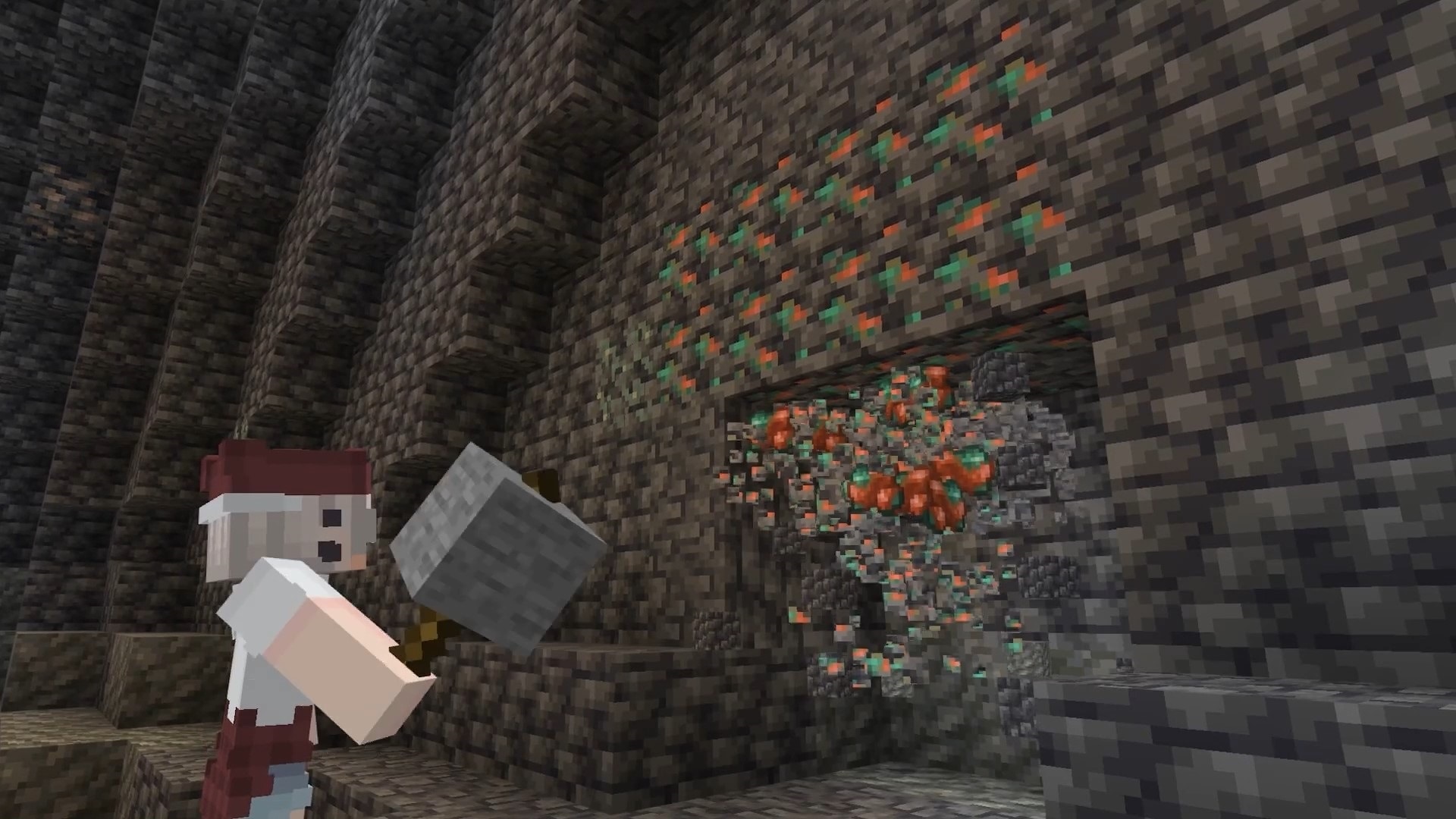 A player uses a large hammer to break multiple copper ore blocks at once inside a cavern.