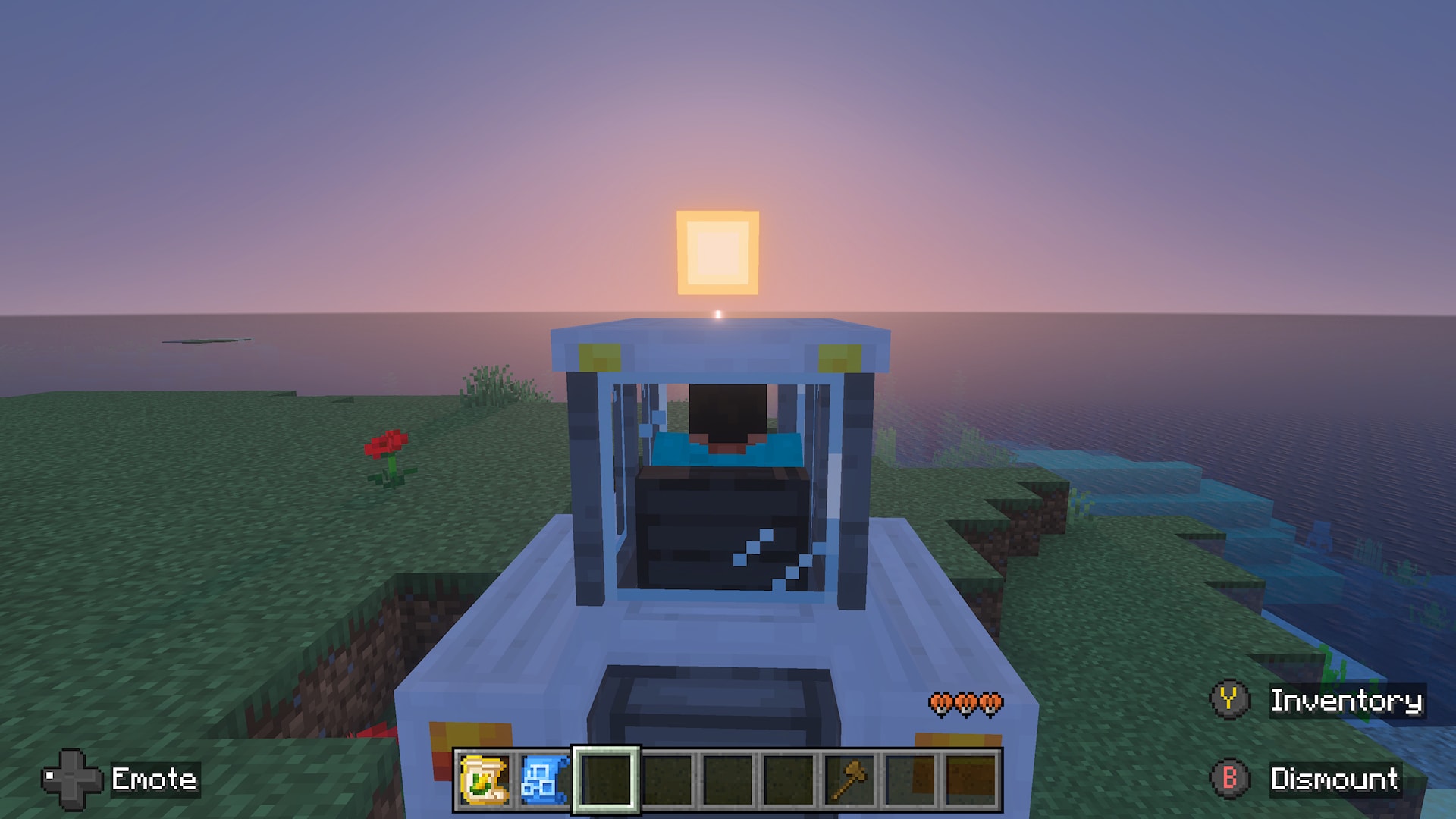 Rear view of a player driving a tractor toward the sunrise along a grassy coastline overlooking the ocean.