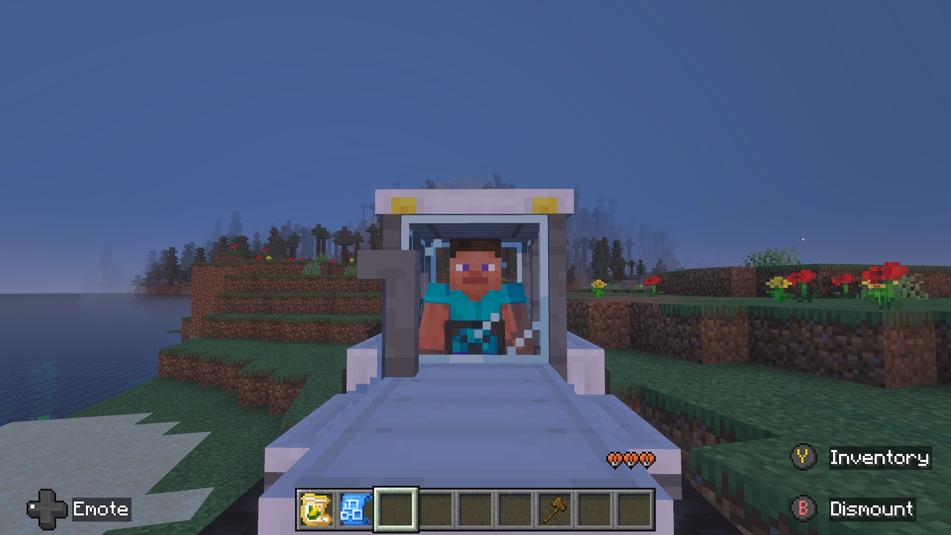 Front view of a player seated in a tractor parked near a coastline, with flowers and trees in the background.