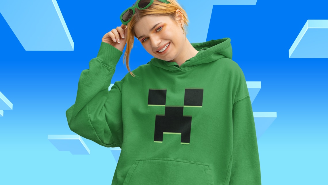 A woman wears a green hoodie with a creeper face on it.