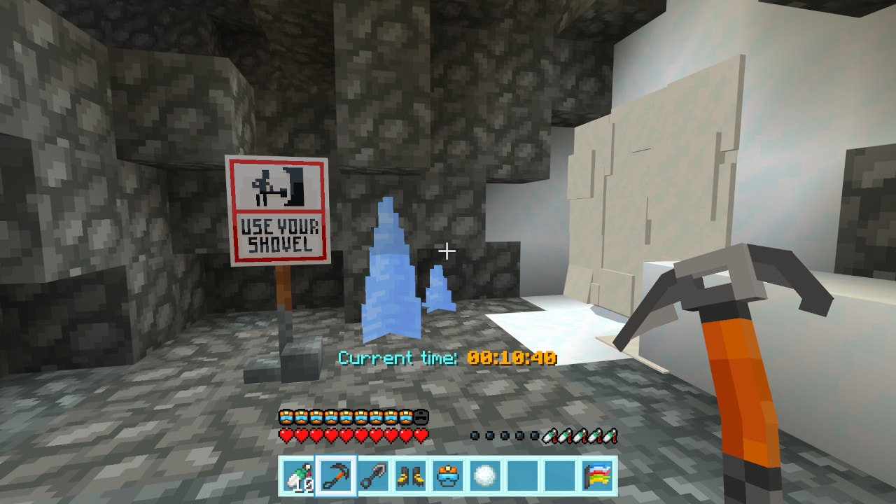 Cave interior with packed snow walls, a warning sign reading Use Your Shovel, and icy formations ahead