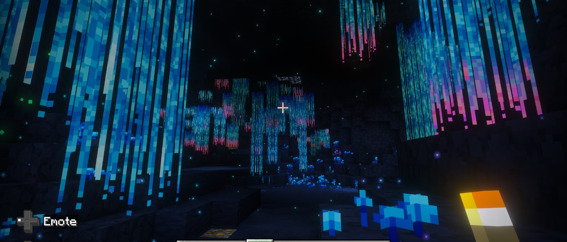 Minecraft underground cavern filled with dramatic hanging blue and pink bioluminescent plants and glowing particles.