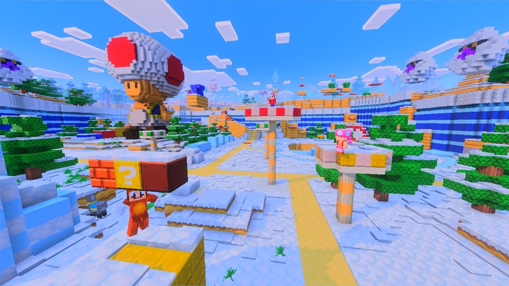 A snowy Minecraft scene features a large Toad statue, question mark and brick blocks, and players dressed as Tanuki Mario, Toadette, and Shy Guy.