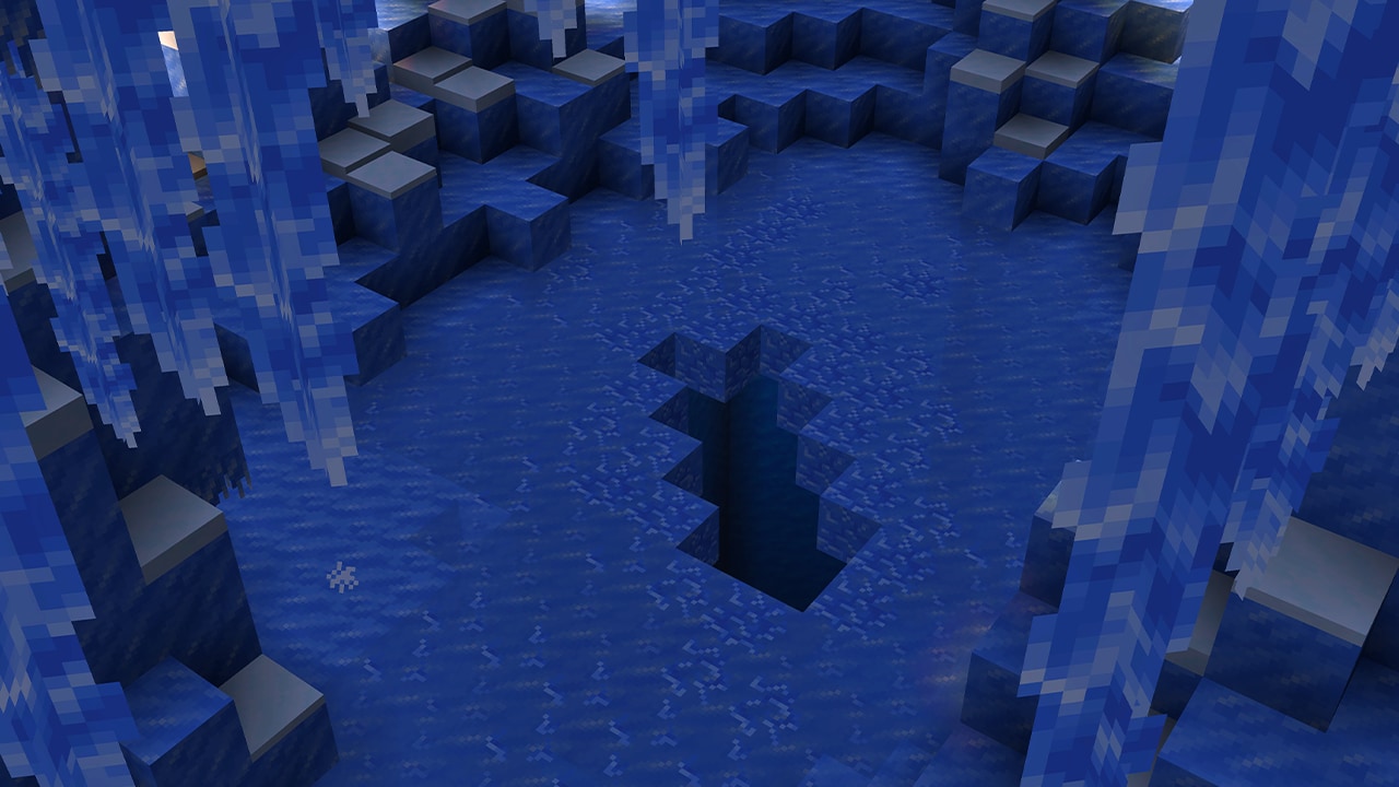 A deep crevasse cutting through an icy cave floor, framed by packed ice formations on either side