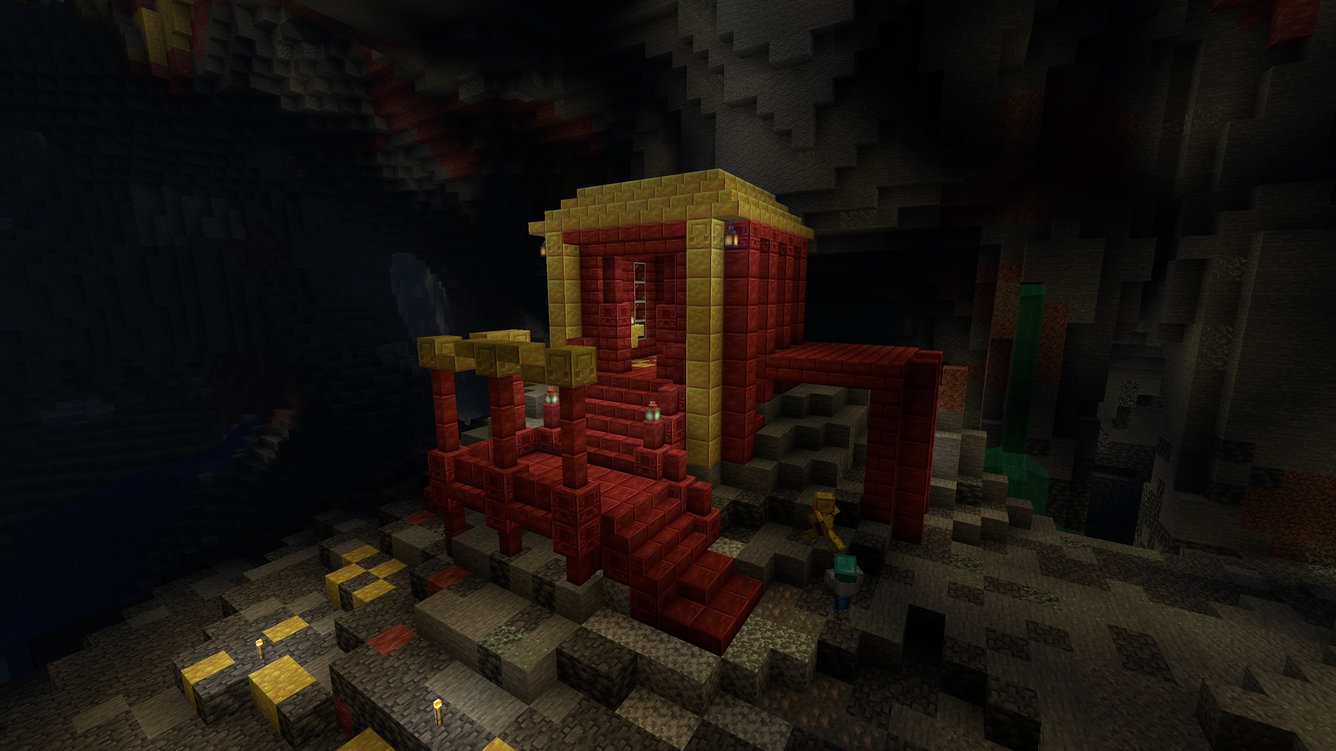 Two players stand next to an underground structure made from polished yellow sulfur blocks and red cinnabar blocks.