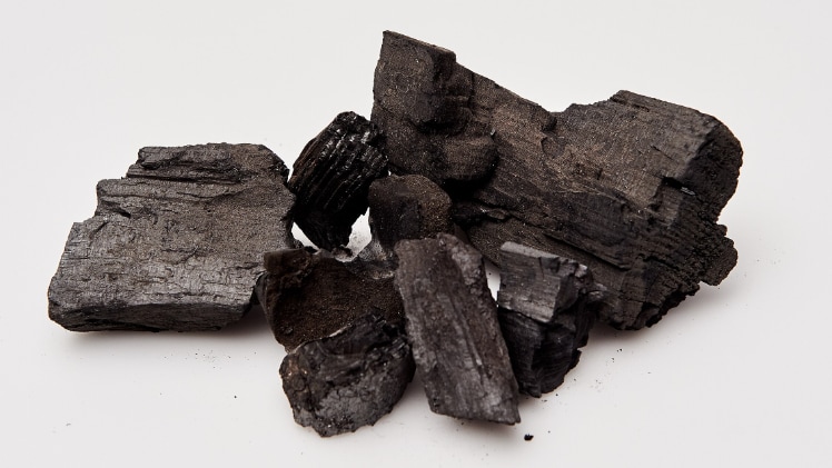 A photo of a pile of charcoal on top of a white background.