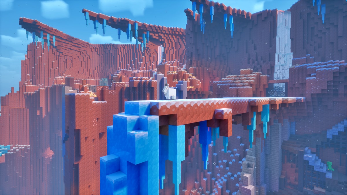 An icy canyon with steep red cliffs, featuring icicles, frozen blocks, layered rock formations, and stone structures built along the edges and across the ravine.
